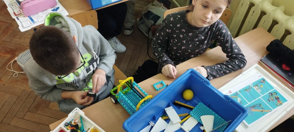 uczniowie układają klocki lego