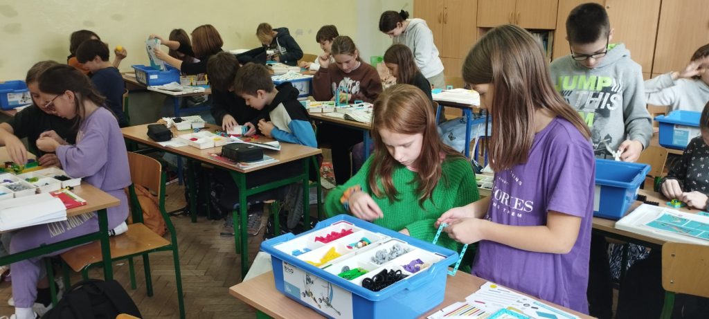 uczniowie układają klocki lego