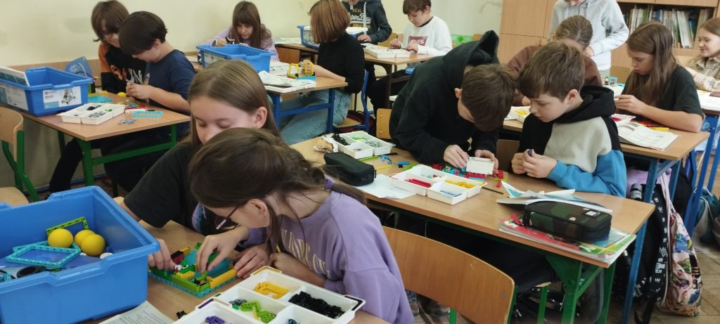 uczniowie układają klocki lego