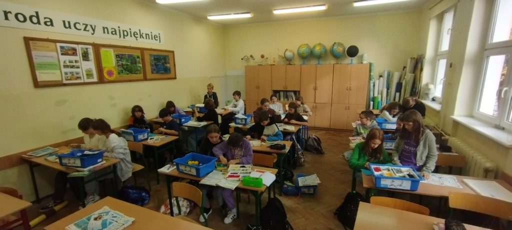 uczniowie układają klocki lego