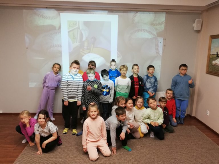 grupa uczniów na tle obrazu z panem kleksem