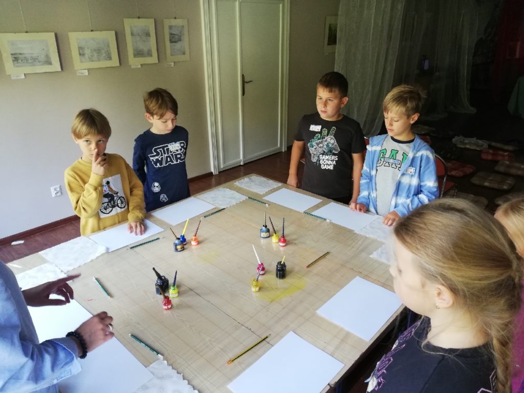 uczniowie przy stole wykonują prace