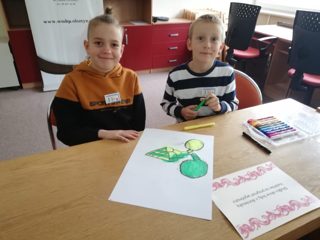 uczniowie przy stole wykonują prace