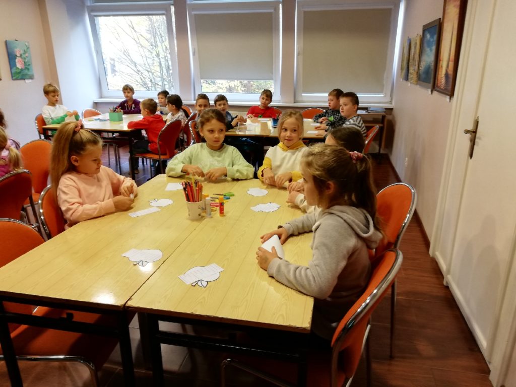 uczniowie przy stole wykonują prace