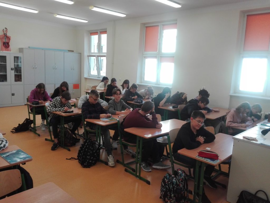 uczniowie siedzący w ławkach