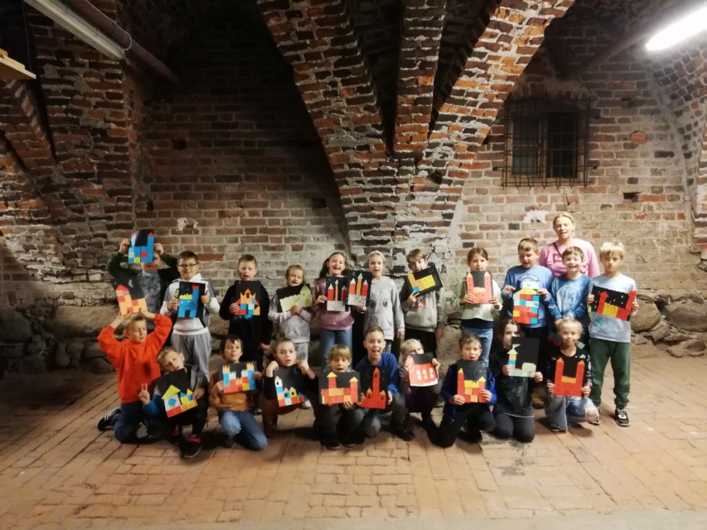 uczniowie na tle ceglanej ściany