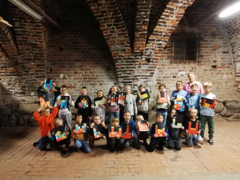 uczniowie na tle ceglanej ściany