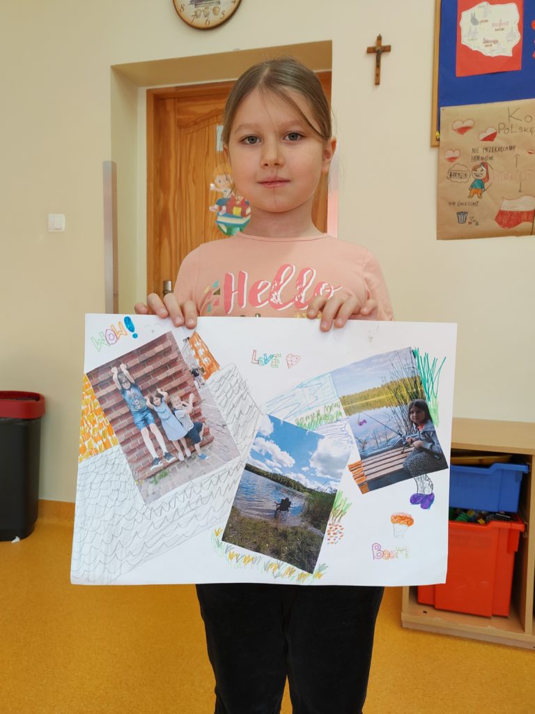 dziewczynka prezentuje swoją prace plastyczną