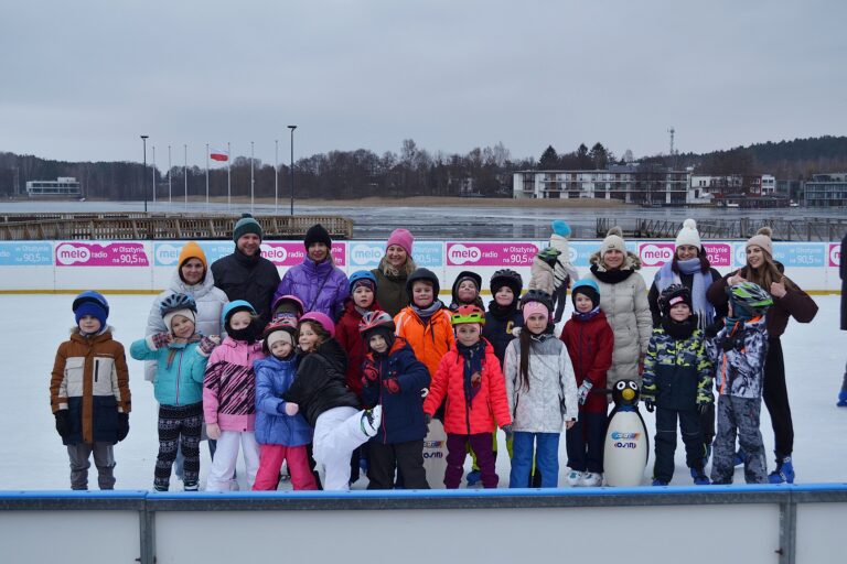 Klasa pozująca do zdjęcia na tle lodowiska.