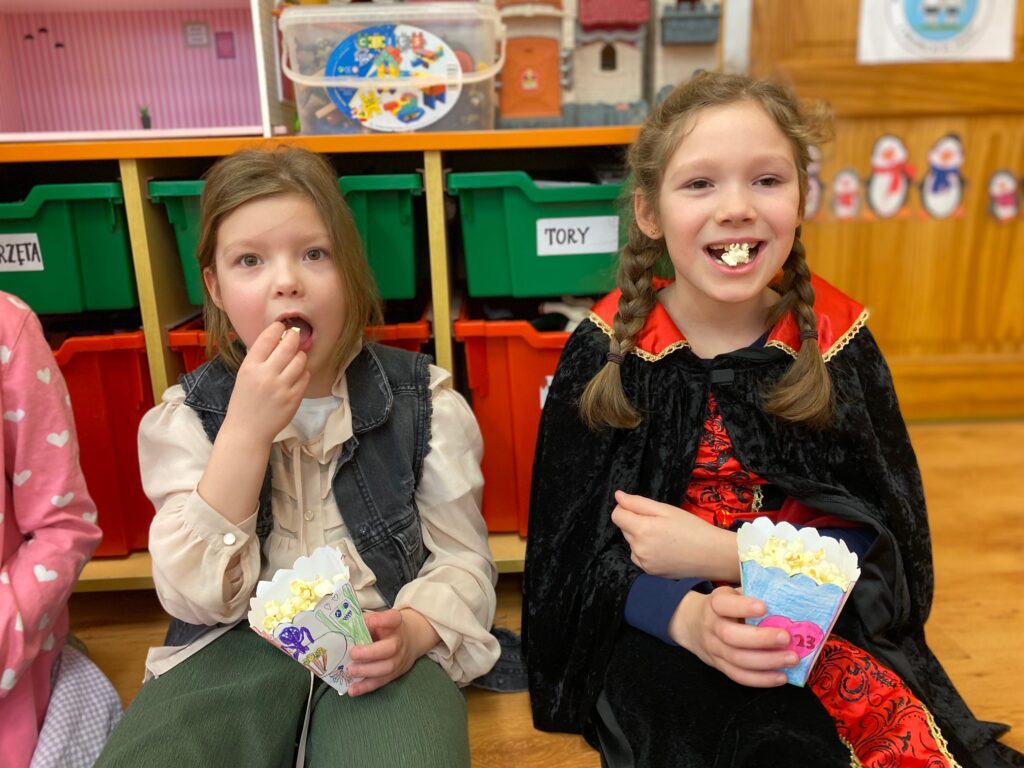 dzieci jedzą popcorn