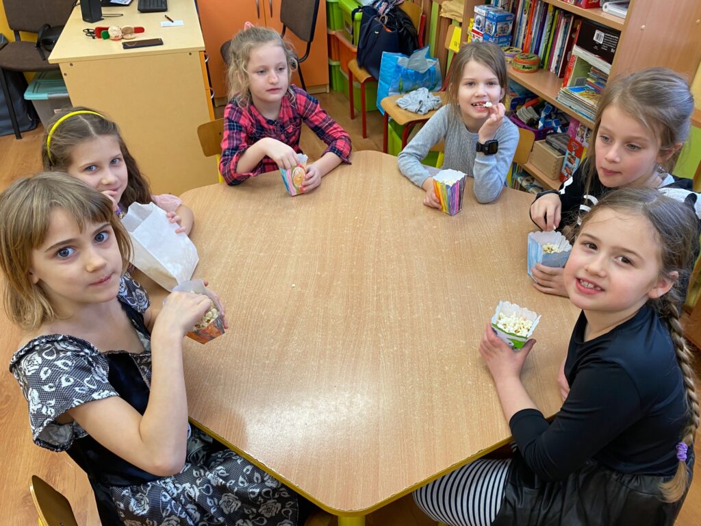 dzieci jedzą popcorn