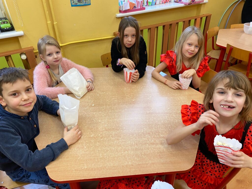 dzieci jedzą popcorn