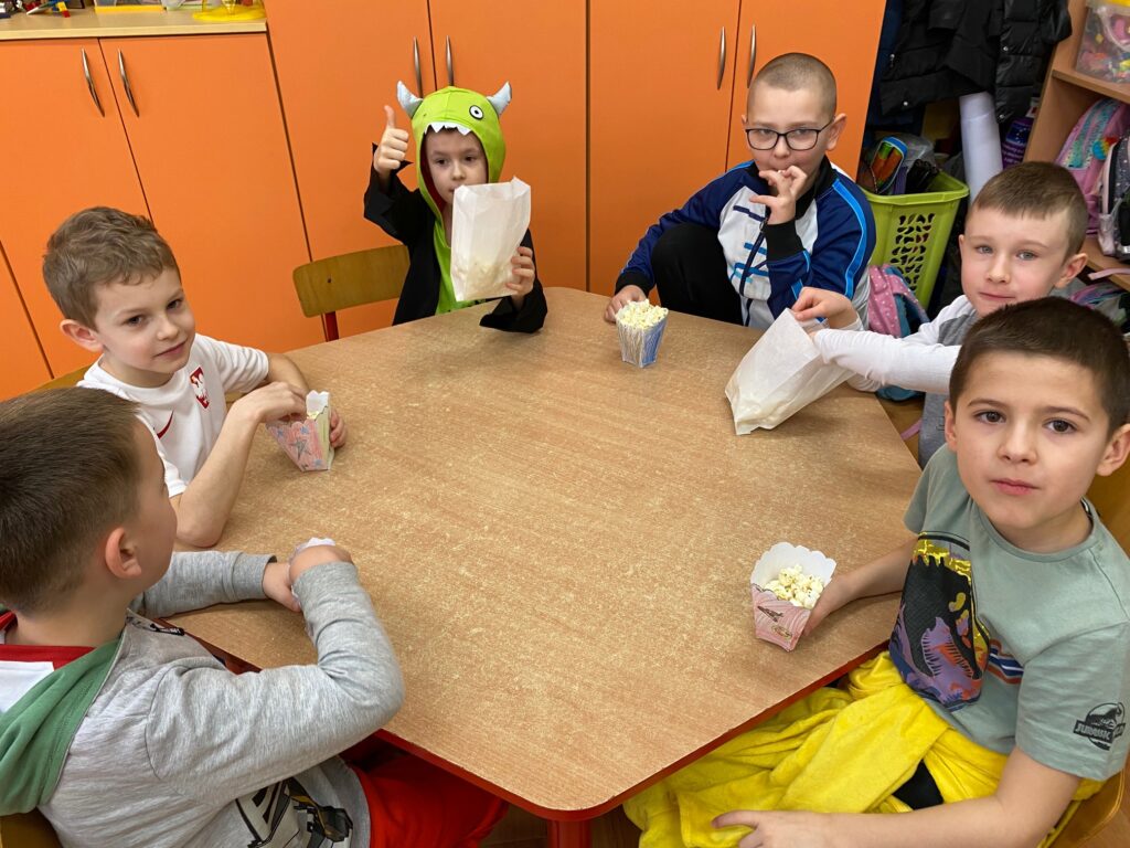 dzieci jedzą popcorn