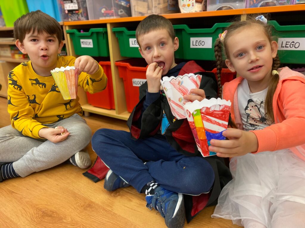dzieci jedzą popcorn
