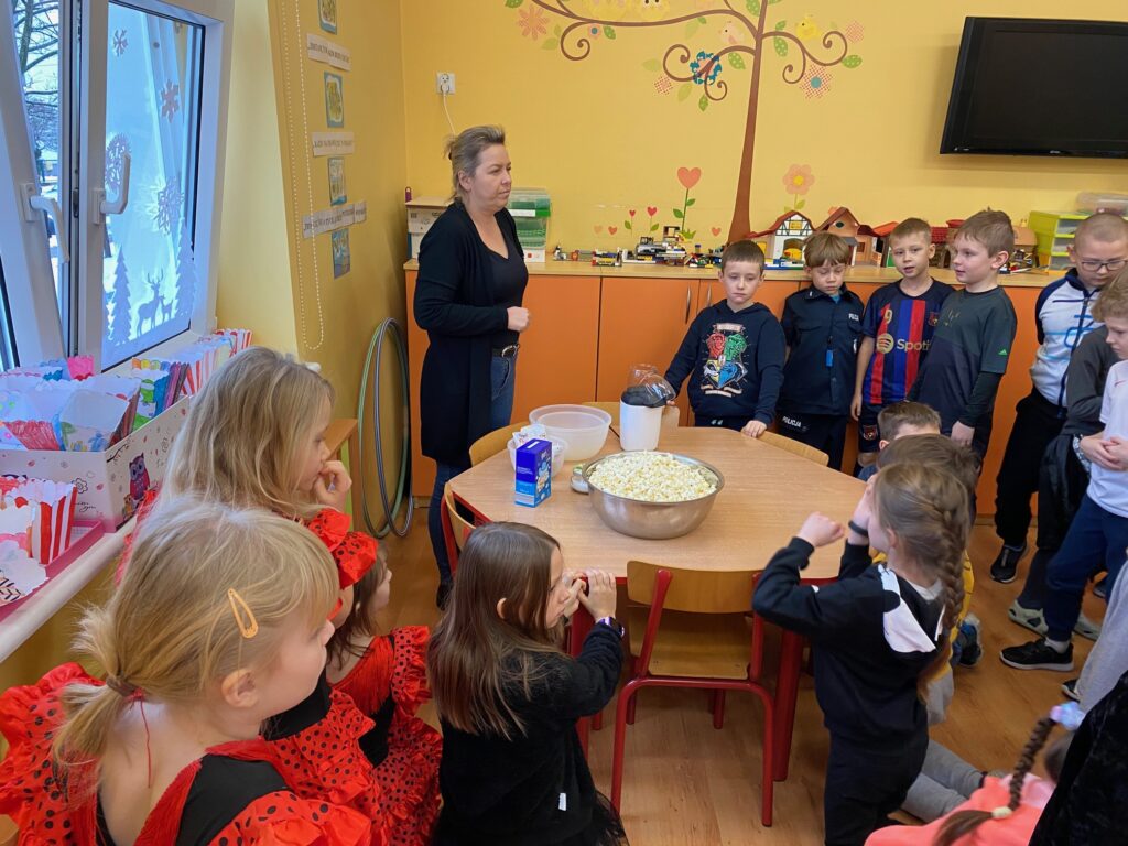 dzieci stoją przy misce z popcornenm