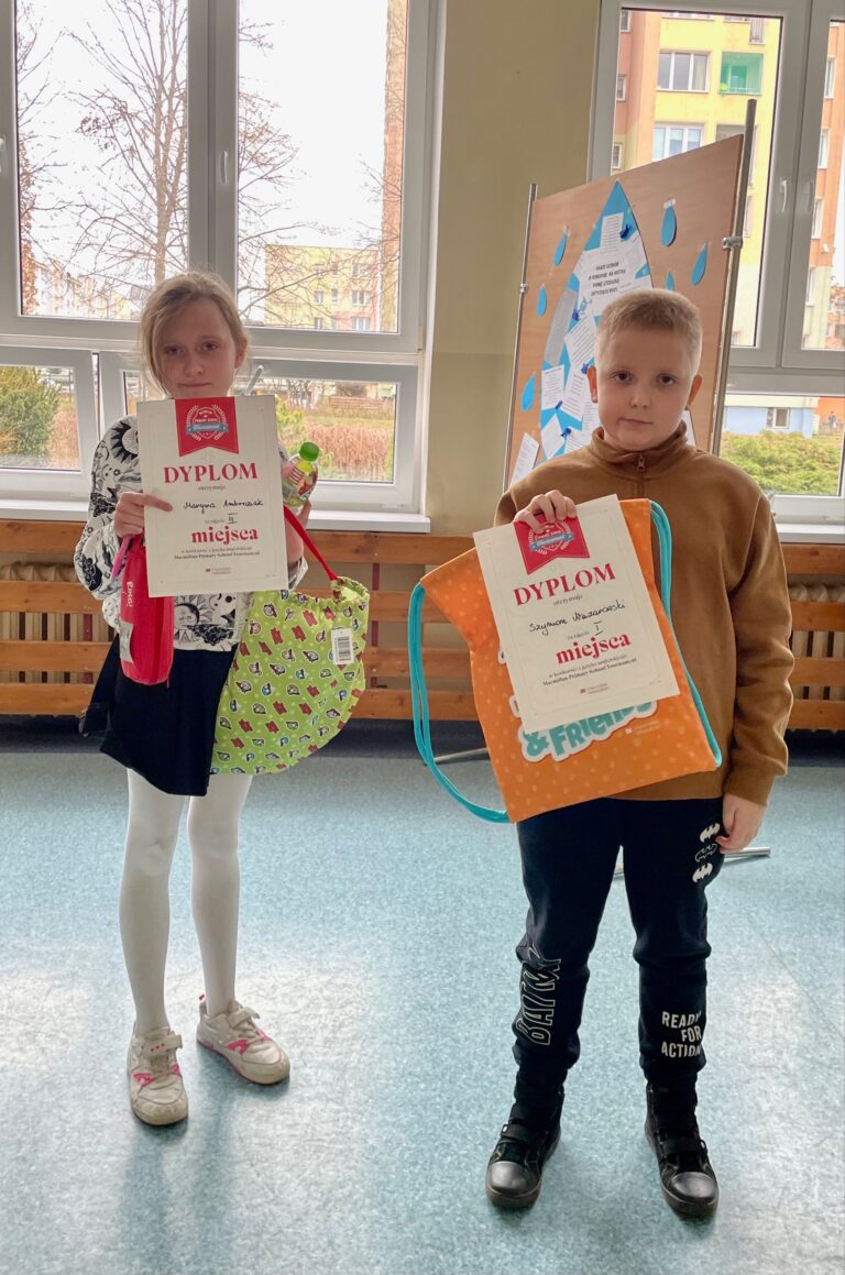 Dziewczynka i chłopiec trzymają w rękach nagrody i dyplomy.