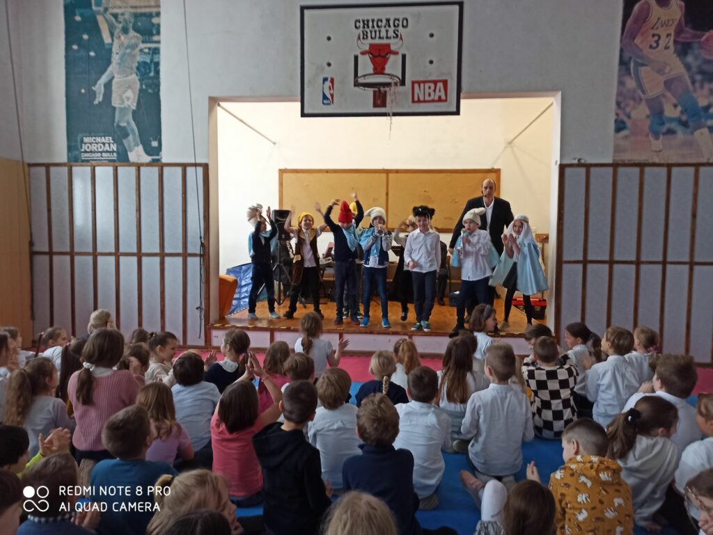 Na zdjęciu w czasie koncertu muzycznego dzieci przebrane za smerfy tańczą, grają na trąbce i saksofonie.