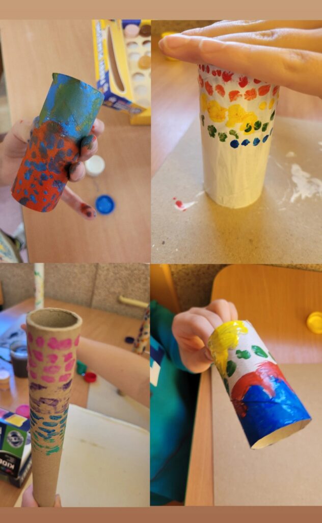 Zdj臋cie jest kola偶em czterech fotografii. W lewym g贸rnym rogu na zdj臋ciu przedstawiona zosta艂a rolka po papierze toaletowym pomalowana na czerwono i niebiesko. W prawym g贸rnym rogu rolka po papierze zosta艂a ozdobiona kolorowymi kropkami na bia艂ym tle, wlot do rolki zosta艂 przes艂oni臋ty d艂oni膮. W prawym dolnym rogu dziecko trzyma rolk臋 po papierze pomalowan膮 we wzory w kolorze niebieskim, czerwonym, 偶贸艂tym i zielonym. Ostatnie zdj臋cie w lewym dolnym rogu przedstawia br膮zow膮 rolk臋 pomalowan膮 w kolorowe plamki.