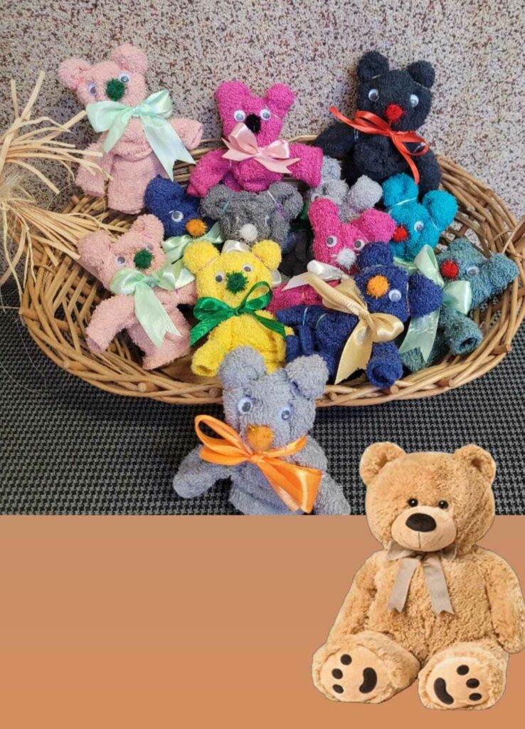 Na zdj臋ciu wida膰 13 r贸偶nokolorowych misi贸w z bawe艂nianych r臋cznik贸w z kokardkami w wiklinowym koszyku. W prawym, dolnym rogu umieszczona jest grafika pluszowego misia.