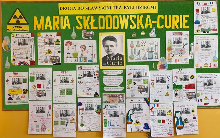 Tablica z wystawą notatek graficznych, sporządzonych przez Świetliczaki, na temat życia i dokonań Marii Skłodowskiej- Curie.