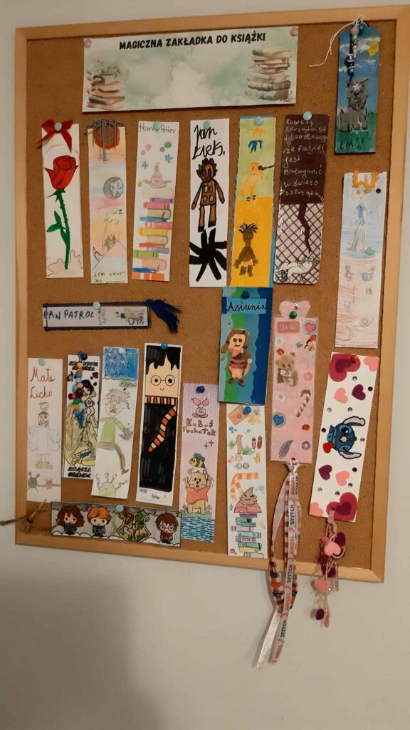 Tablica korkowa z ekspozycją zakładek do książek wykonanych przez uczniów. Zakładki są różnorodne, każda z nich przedstawia motywy związane z ulubionymi bohaterami literackimi uczestników. Prace są bardzo kolorowe, wykorzystano różne techniki artystyczne, od rysunków po ozdobne elementy i naklejki. Każda zakładka przypięta jest pinezką.