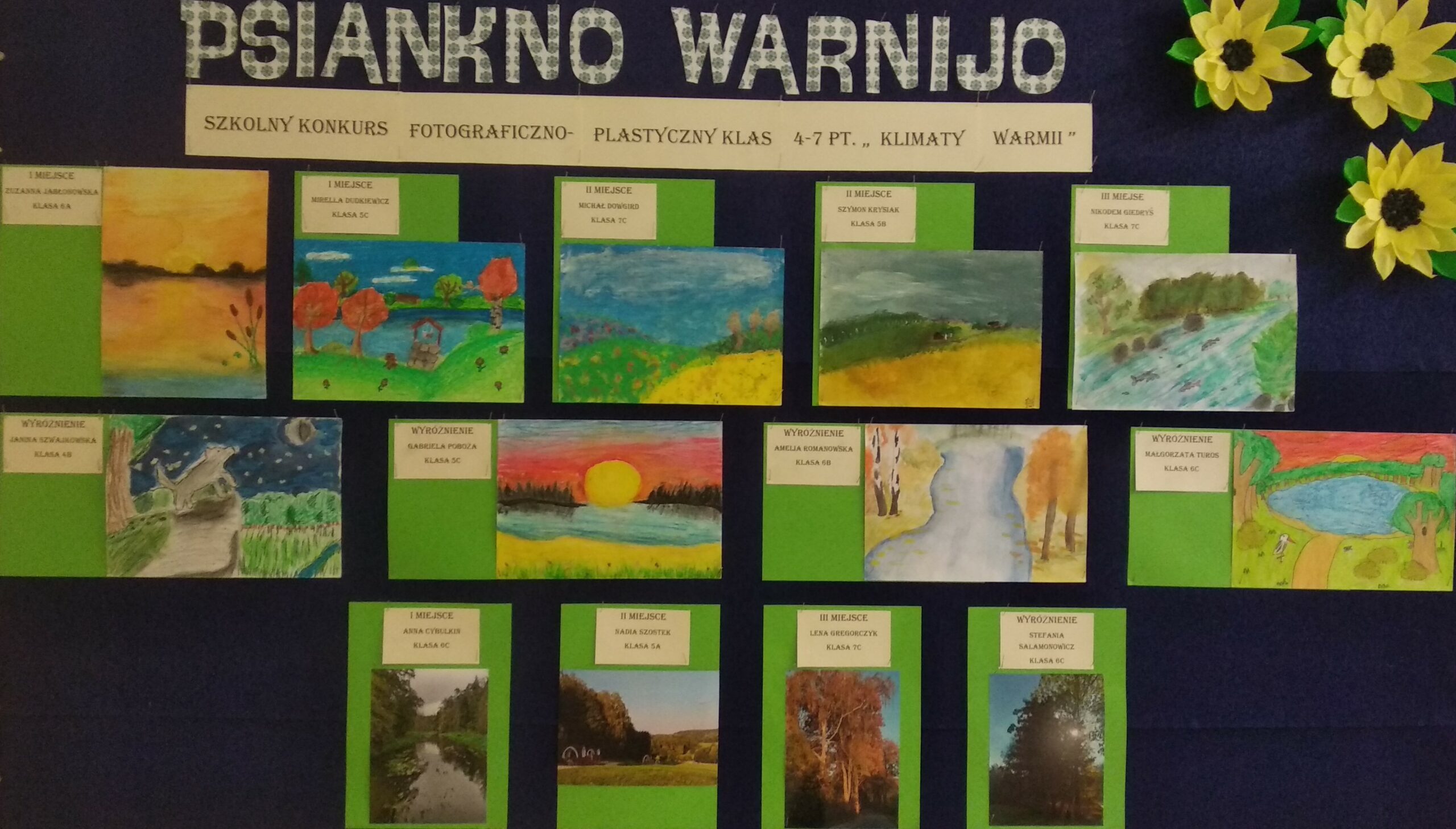 Zdjęcie przedstawia prace laureatów Szkolnego Konkursu Fotograficzno- Plastycznego klas 4-7 pt.,,Klimaty Warmii”. Nad pracami znajduje się napis po warmińsku Psiankno Warnijo, a pod nim napis Szkolny Konkurs Fotograficzno- Plastyczny klas 4-7 pt.,,Klimaty Warmii”. Prace ułożone są w trzech rzędach: 2 pierwsze rzędy to prace plastyczne(w pierwszym rzędzie znajduje się pięć prac, w drugim cztery), w trzecim znajduję się 4 fotografie. Wszystkie prace przedstawiają krajobrazy warmińskie.