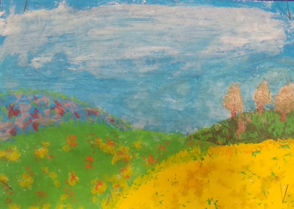 Przedstawia krajobraz warmiński-który przedstawia pole z żółtymi łanami zboża i łąkę z kwiatami, w oddali widoczne są drzewa.