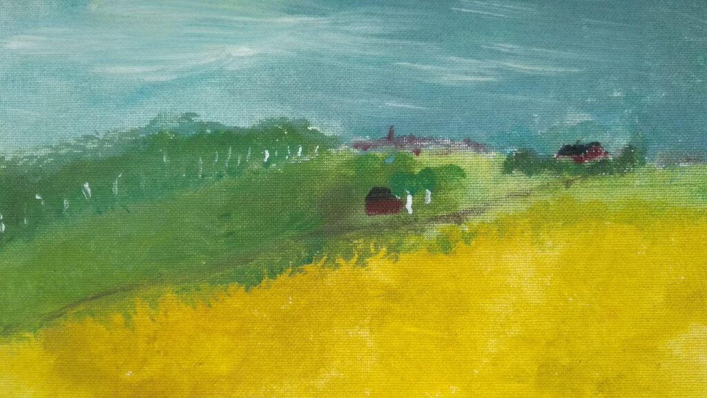 Przedstawia krajobraz warmiński-z przodu znajduje się pole z żółtymi łanami zboża, w oddali widoczne są drzewa i zabudowania.