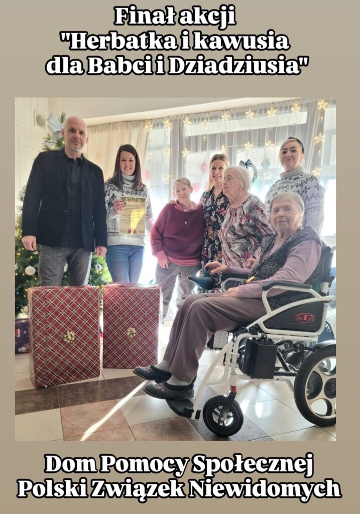 Na zdjęciu widzimy finał akcji "Herbatka i kawusia dla Babci i Dziadziusia", który odbył się w Domu Pomocy Społecznej Polskiego Związku Niewidomych. Grupa osób, w tym starsi mieszkańcy domu i organizatorzy wydarzenia, pozuje na tle udekorowanej choinki oraz świątecznych ozdób. Dwie starsze kobiety siedzą, jedna z nich na wózku inwalidzkim, a za nimi stoją cztery osoby – dwie kobiety w zimowych swetrach, jedna trzymająca dyplom, oraz mężczyzna w eleganckim stroju. Na pierwszym planie znajdują się dwa duże, zapakowane prezenty, co podkreśla świąteczny charakter wydarzenia. Atmosfera na zdjęciu jest ciepła i serdeczna.