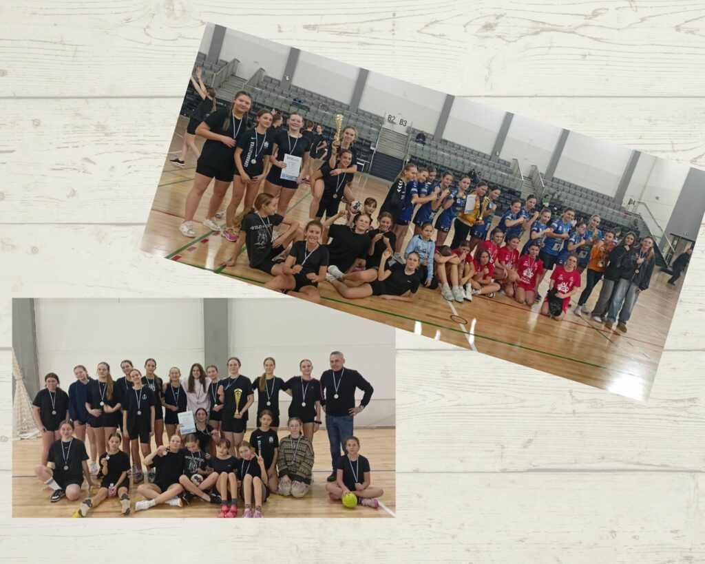 Zdjęcie przedstawia grupę dziewcząt w czarnych sportowych strojach siedzących i stojących na parkiecie hali sportowej. Dziewczyny mają na szyjach medale, a jedna z nich trzyma dyplom, co sugeruje, że zdobyły wyróżnienie w turnieju. W tle widać trybuny oraz inne drużyny, w tym zawodniczki w niebieskich i czerwonych strojach, które również pozują z medalami. Cała scena odbywa się w dużej hali sportowej z jasnym oświetleniem.