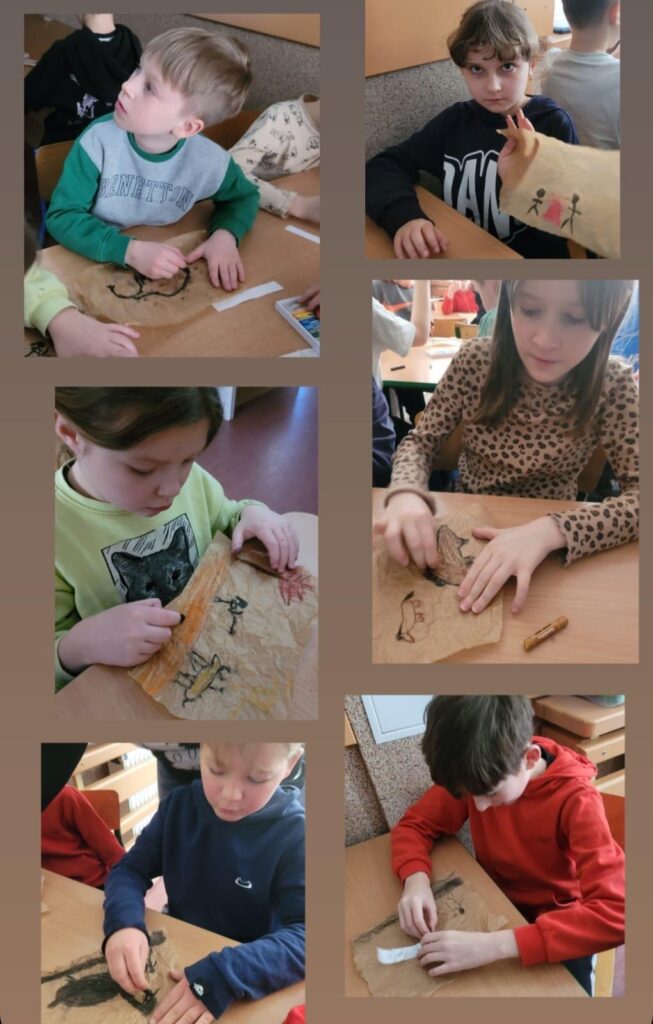 Zdjęcie przedstawia grupę dzieci biorących udział w zajęciach plastycznych, podczas których tworzą rysunki inspirowane malarstwem jaskiniowym. Opis zdjęcia: Składa się ono z sześciu mniejszych ujęć, na których dzieci pracują przy stolikach, rysując na postarzonej, pomarszczonej kartce, przypominającej skórę lub pergamin. Technika: używane są węgiel, pastele i kredki w kolorach ziemi (brązy, czernie, czerwienie, pomarańcze). Tematyka rysunków: widać prymitywne postacie ludzkie, zwierzęta, ogniska, symbole – nawiązujące do prehistorycznych malowideł naskalnych. Dzieci są skupione i zaangażowane, każda praca jest unikalna, a uczniowie eksperymentują z różnymi formami i stylami. To kreatywna i edukacyjna lekcja, która pozwala dzieciom przenieść się w świat dawnych cywilizacji i poczuć się