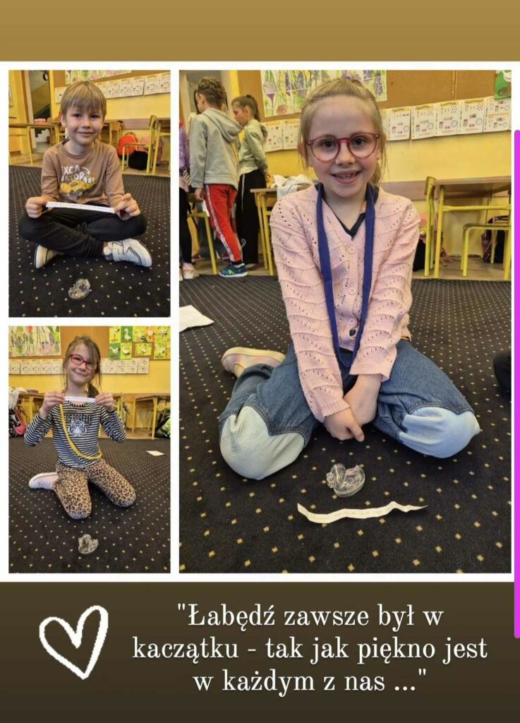 Na zdjęciu widzimy trzy radosne dzieci siedzące na dywanie w klasie. Każde z nich trzyma w dłoniach pasek papieru z cytatem, a przed nimi stoi mała figurka łabędzia. W tle widać inne dzieci oraz kolorowe rysunki zawieszone na ścianach. Na dole obrazka znajduje się cytat: „Łabędź zawsze był w kaczątku – tak jak piękno jest w każdym z nas…” Towarzyszy mu narysowane serduszko, podkreślające przesłanie o wewnętrznym pięknie i wyjątkowości każdego dziecka.