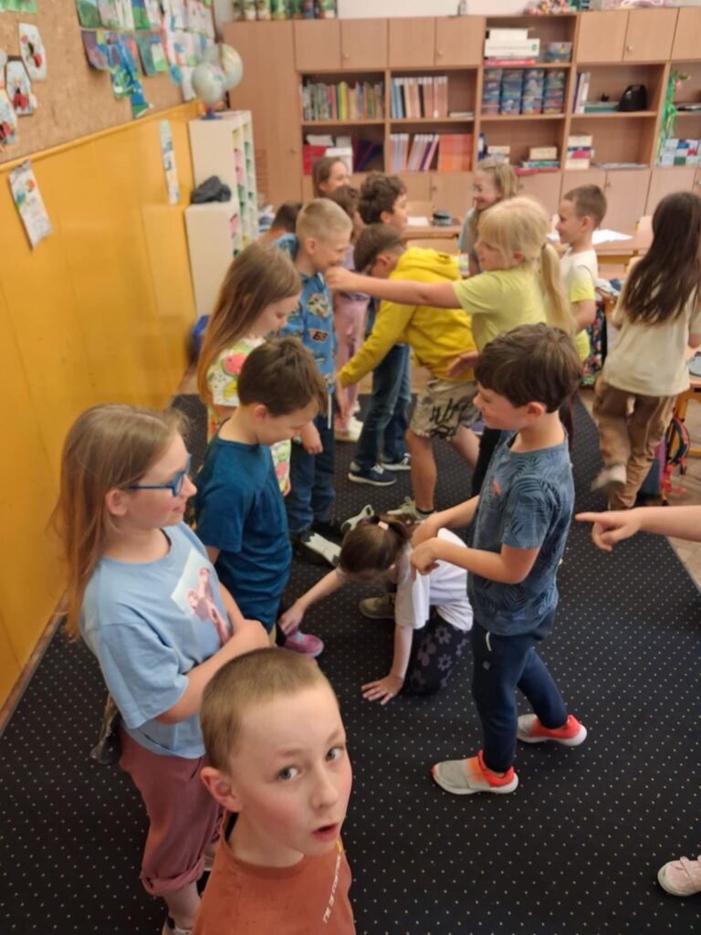 W klasie szkolnej stoją dzieci w parach, na przeciwko siebie. Rozpoznają różnice w ubiorze kolegi.