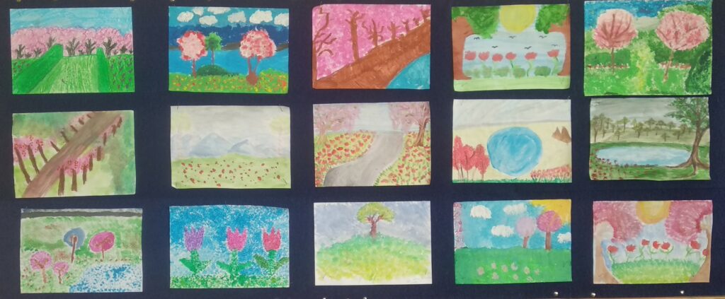 Na zdjęciu znajdują się prace uczniów przestawiających krajobrazy wiosenne. Prace ułożone są w trzech rzędach po 5 prac. Prace przedstawiają kwitnące drzewa, krzewy, kwiaty.